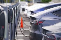 long line of unsold 2020 models charge outside a Tesla dealership